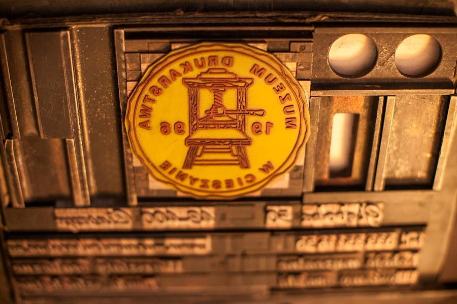Logotyp Muzeum Drukarstwa na prasie drukarskiej